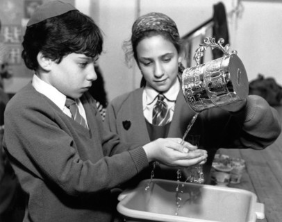 Jewish children performing ritual hand-washing, April 1991. Artist: Sidney Harris
