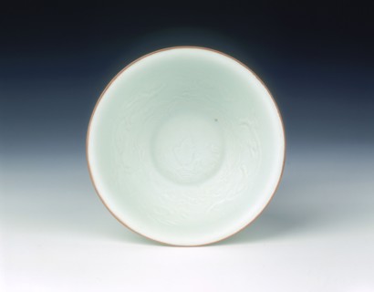 White glazed bowl with moulded design of dragons and carp, Qing dynasty, China, 1650-1670. Artist: Unknown