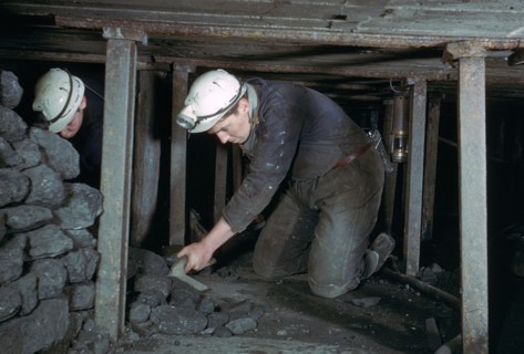 Loading coal onto a conveyer.