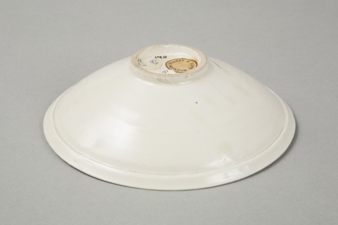 A shallow cream glazed bowl with rolled rim andraised footrim, Tang dynasty, c.800-900. Artist: Unknown.