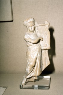Greek Terracotta, Woman playing Kithera with plectrum, 3rd century BC-2nd century BC Artist: Unknown.