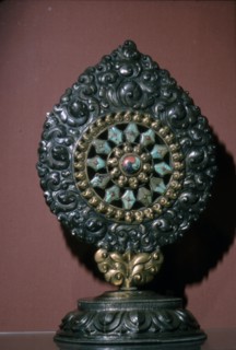 Tibetan Wheel of the Law inlaid with turquoise and coral. Artist: Unknown.