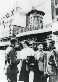 Des soldats allemands discutant avec des Françaises devant le Moulin Rouge, Paris occupé, juin 1940