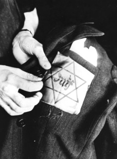 Sewing the yellow star identifying a Jew onto a jacket, German-occupied Paris, 1942. Artist: Unknown