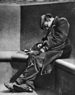 A man sleeping on Blackfriars Bridge, London, 1926-1927.Artist: Walter Benington
