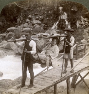 Japanese woman in a yamakago (mountain chair) crossing the torrential Daiya river near Nikko, Japan,Artist: Underwood & Underwood