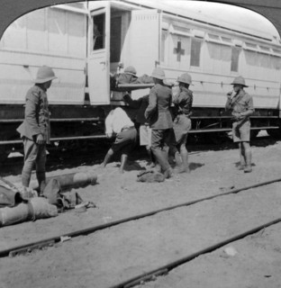 Lifting wounded soldiers onto a hospital train, East Africa, World War I, 1914-1918.Artist: Realistic Travels Publishers