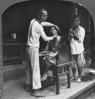 A Chinese barber at Bhamo, Burma, 1908. Artist: Stereo Travel Co
