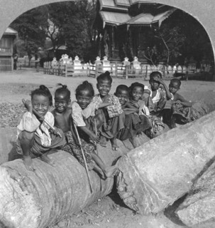 Burmese children sitting on a palm log, Burma, 1908. Artist: Stereo Travel Co