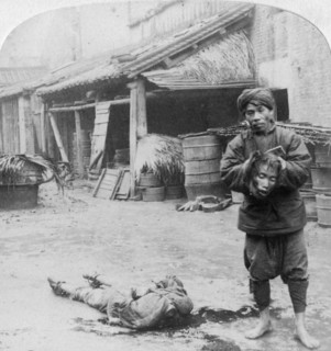 'The grim executioner taking the labled head to exhibit a warning', Canton, China, 1900.  Artist: Underwood & Underwood