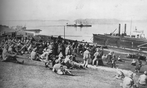 ''Austrian prisoners taken by Serbians resting at mid-day on the banks of the Danube', 1915.  Artist: Unknown.