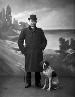 Elegant man wearing a black overcoat posing with his dog, Landskrona, Sweden, 1910. Artist: Unknown