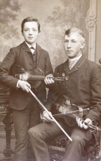 A father and son posing with their violins. Artist: Unknown
