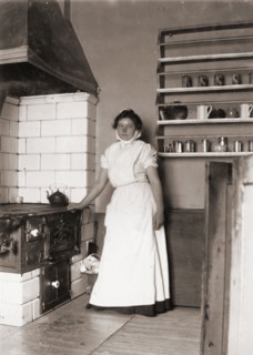 A maid, named Ruth, by the stove, 1905. Artist: Unknown