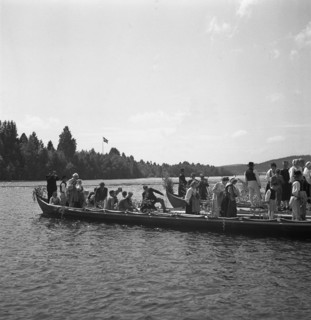 People arrive in long boats, called church boats, for the Midsummer celebrations, Sweden, 1941. Artist: Torkel Lindeberg