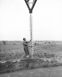 Electricity power insulator, cables and worker up a pylon, Nottinghamshire,c1950s-1960s(?). Artist: CEGB
