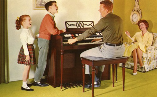Family singing around a Wurlitizer organ as father plays, De Kalb, Illinois, USA, 1962. Artist: Unknown