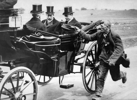 Beggar holidng out his cap as he passes King George V in a carriage, c1911-1936. Artist: Unknown