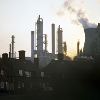 A petrochemical plant towering over residential housing, Baglan Bay, Wales, 1975. Artist: Michael Walters