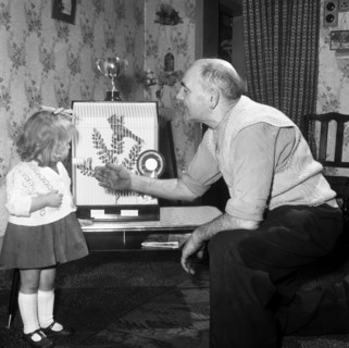 Grandfather and child with a prize winning caged bird, Horden, County Durham, 1963. Artist: Michael Walters