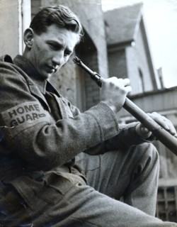 British Home Guard soldier cleaning his rifle, World War II, c1940-c1944. Artist: Unknown