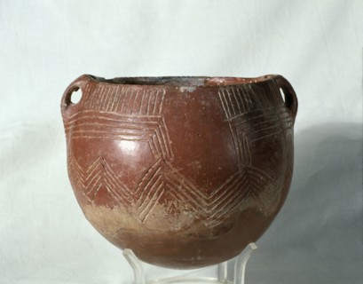Red ochre glass (painted with a red slip of iron oxide), with incised parallel lines that form ge?