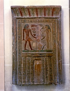 Door shaped stela representing Senouret and his wife in front of their offerings, made in polychr?