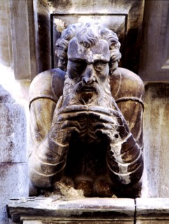 Façade of the Paeria of Cervera, anthropomorphic corbel of a personage stroking his beard.