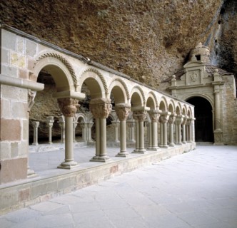 View of the arches and geminated columns of the cloister by the rocks of the Benedictine monaster?