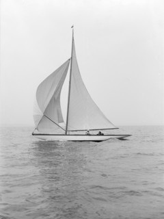 The 6 Metre class 'Marmi' sailing under spinnaker, 1914. Creator: Kirk & Sons of Cowes.