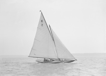 The 7 Metre yacht 'Ithnan' (K2) sailing close-hauled, 1911. Creator: Kirk & Sons of Cowes.