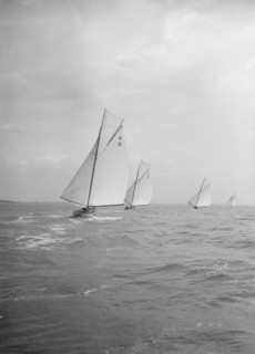 Group of 8 Metres sailing yachts racing downwind, 1913. Creator: Kirk & Sons of Cowes.
