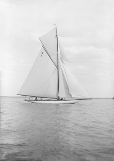 The 12 Metre cutter 'Alachie' sailing in gentle winds, 1913. Creator: Kirk & Sons of Cowes.