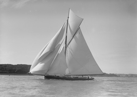 The gaff rigged cutter 'Bloodhound' sailing downwind under spinnaker, 1911. Creator: Kirk & Sons of Cowes.