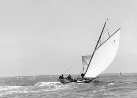 The 8 Metre sailing yacht 'Dilkusha' setting spinnaker, 1911. Creator: Kirk & Sons of Cowes.
