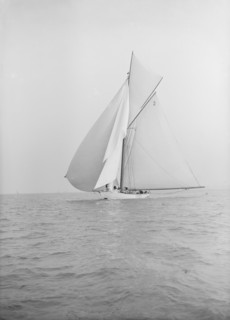 The 40-rater cutter 'Carina' sailing with spinnaker, 1913. Creator: Kirk & Sons of Cowes.