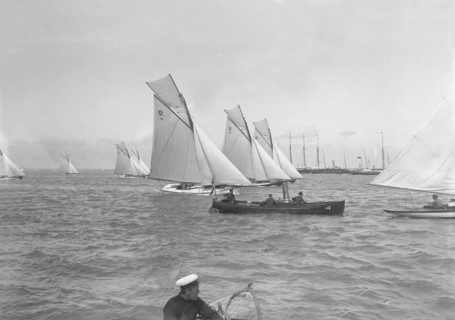 Sailing yachts cross start line. Creator: Kirk & Sons of Cowes.