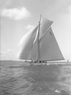 'Davo III', a 12 Metre class sailing yacht, runs before the wind, 1911. Creator: Kirk & Sons of Cowes.