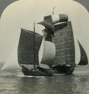 'Picturesque Chinese Junk under Full Sail on the Yellow Sea, Coast of Manchukuo in Distance', c1930s Creator: Unknown.
