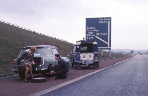 Austin A40 Farina having wheel changed by R.A.C breakdown assistance. Creator: Unknown.