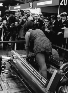 Female model climing in to Cooper F5000 at 1969 Racing Car show. Creator: Unknown.