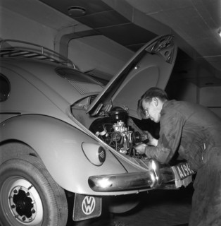 Car mechanic servicing a Volkswagen, Vallingby, Sweden, 1956. Creator: Unknown.