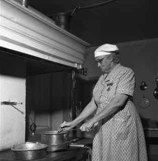 Housewife at the fireplace, Abonas, Sweden, 1956. Creator: Unknown.