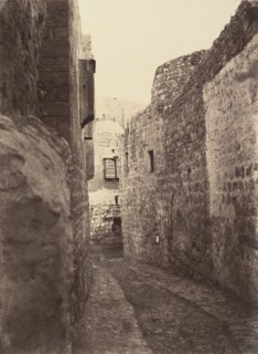Ve Station. Jésus aidé par Simon de Cyrène. Une marque dans le mur indique seule cette station. La maison que l'on voit au fond est celle du mauvais riche, 1860 or later.