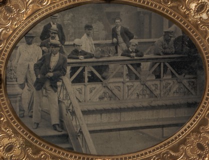Group of Men and Boys Standing Along the Railing of the Fulton Street Bridge, 1866-68.