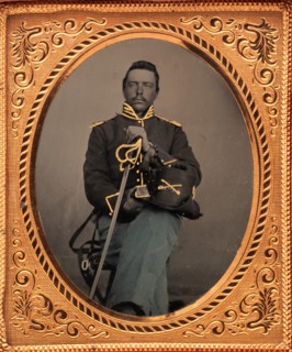 Union Cavalry Officer Displaying Sword, Holding Hat, Seated in Studio, 1861-65.