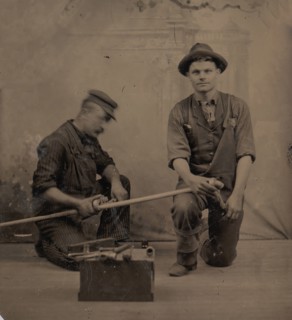 Two Plumbers with a Pipe, Pipe Cutter, and Toolbox, 1870s-80s.