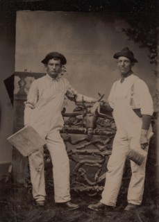 Two Plasterers in Overalls Leaning on a Rustic Fence, 1870s-80s.