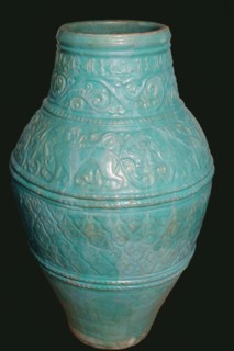 Large Turquoise Jar, Iran, 12th-13th century. Motifs typical of the Seljuq period including winged griffins and arabesque design. with inscriptions of good wishes  in small kufic script.