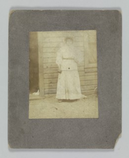 Photographic print of a woman in front of a building, late 19th century. Creator: Unknown.